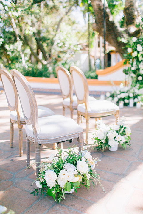 Rancho-las-lomas-blue-shoot-ceremony-chairs-in-a-light-wooden-stlye-with-white-linens-and-green-florals