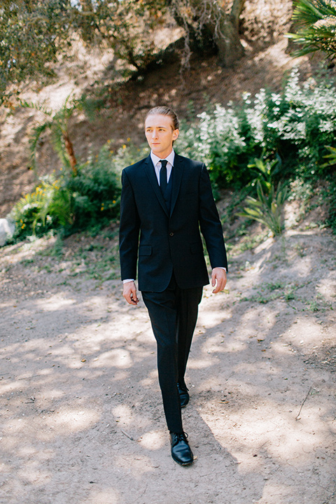 Rancho-las-lomas-blue-shoot-groom-walking-a-black-notch-lapel-suit-and-black-long-tie