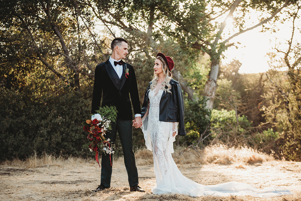 owl-creek-farms-bride-and-groom-touching-heads-bride-wearing-a-boho-lace-long-sleeved-gown-with-a-high-neckline-groom-wears-a-black-velvet-coat-with-grey-pants-and-a-black-bow-tie