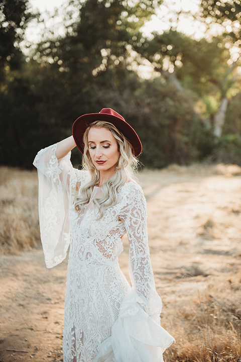 owl-creek-farms-bride-wearing-hat-bride-wearing-a-boho-style-dress-with-long-sleeves-and-a-high-neckline-with-a-burgundy-wide-brimmed-hat