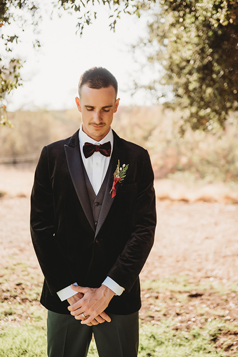 owl-creek-farms-groom-looking-down-wearing-a-velvet-tuxedo-with-grey-pants