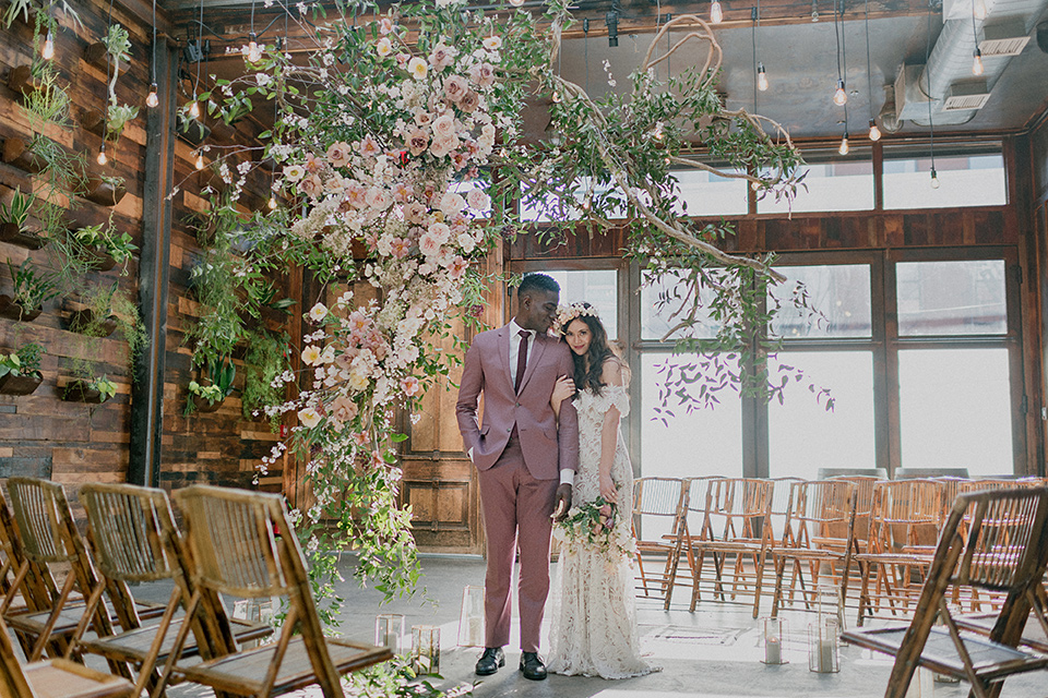 Brooklyn-Shoot-bride-and-groom-in-ceremony-space-groom-in-a-rose-pink-suit-with-brown-shoes-the-bride-in-a-lace-boho-style-gown