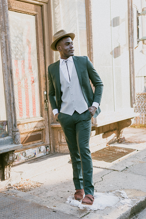 Brooklyn-Shoot-groom-looking-up-in-a-green-suit-with-a-grey-vest-and-a-bolo-tie