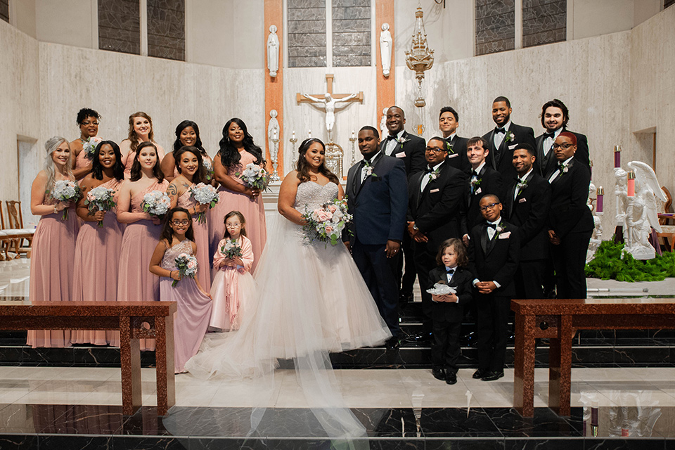 Fete-Venue-New-Orleans-Wedding-bridal-party-bridesmaids-in-pink-dresses-groomsmen-in-black-tuxedos-bride-in-a-tulle-strapless-ballgown-groom-in-a-navy-blue-tuxedo