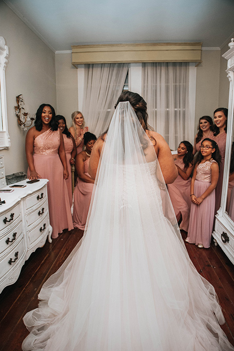 Fete-Venue-New-Orleans-Wedding-bride-looking-at-bridesmaids-bridesmaids-facing-camera-bridesmaids-in-pink-dresses-bride-in-a-strapless-ball-gown