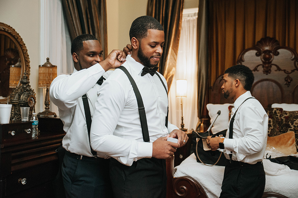 Fete-Venue-New-Orleans-Wedding-groom-getting-ready-groom-in-navy-tuxedo-with-a-shawl-lapel-and-groomsman-and-groomswoman-in-black-tuxedos