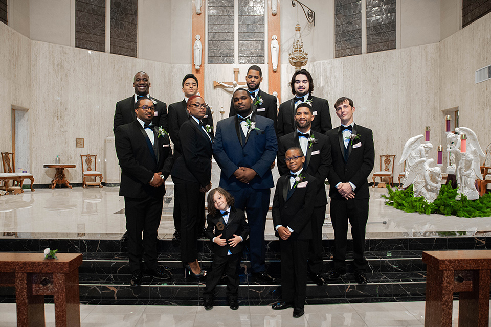 Fete-Venue-New-Orleans-Wedding-groomsmen-groom-in-navy-tuxedo-with-a-shawl-lapel-and-groomsman-and-groomswoman-in-black-tuxedos