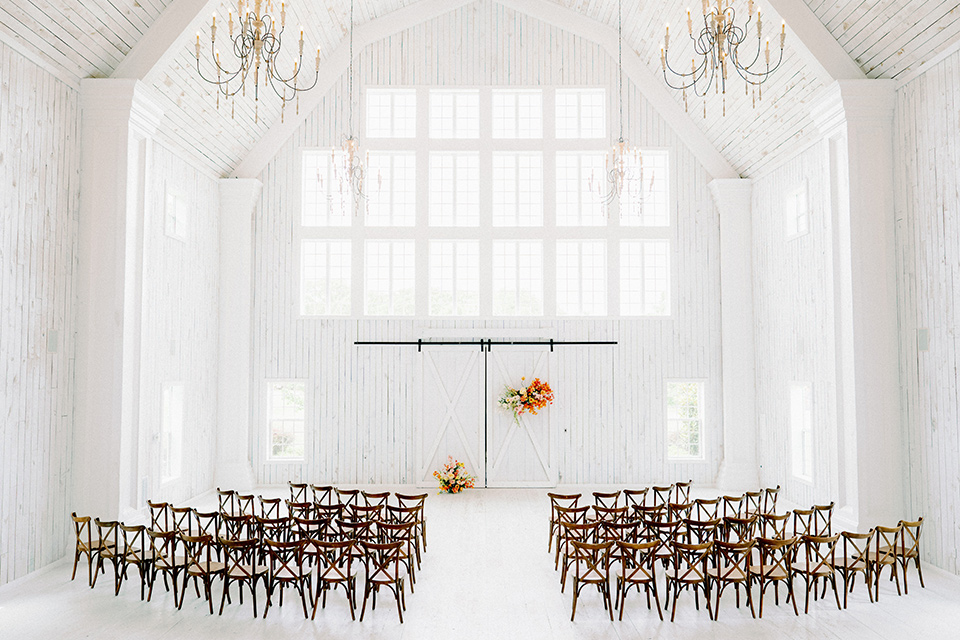 white barn interior with wooden chairs and golden florals