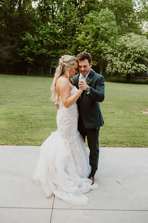 Horse-Range-Vista-couple-dancing-bride-in-a-lace-mermaid-gown-with-a-sweetheart-neckline-groom-in-a-green-suit-with-a-floral-tie