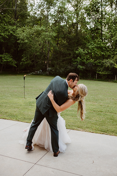 Horse-Range-Vista-couple-daning-at-reception-bride-in-a-lace-strapless-mermaid-gown-and-groom-in-a-green-suit-with-floral-tie