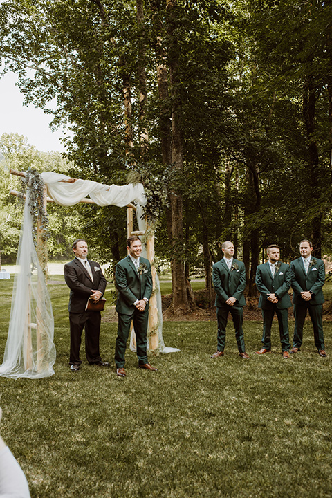 Horse-Range-Vista-groom-at-ceremony-in-a-green-suit-with-a-floral-tie