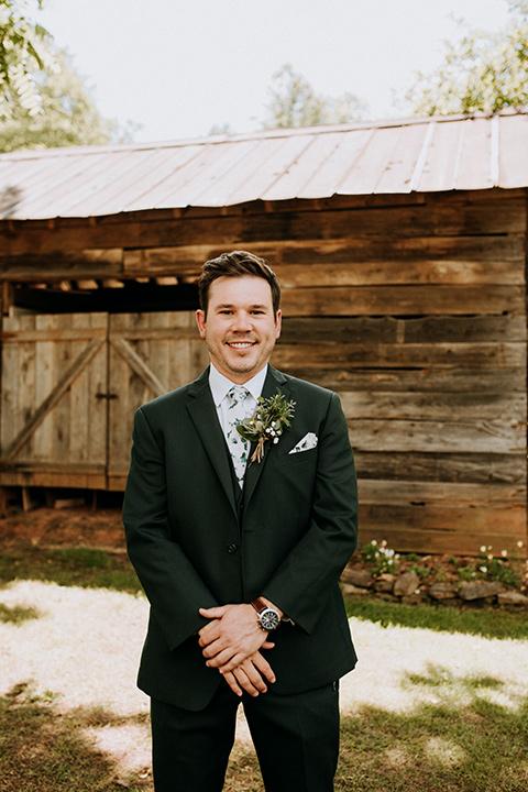 Horse-Range-Vista-groom-standing-in-a-green-suit-with-floral-tie