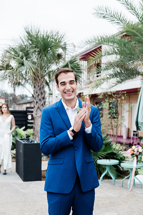 groom is in a cobalt blue suit with brown shoes and his shirt undone