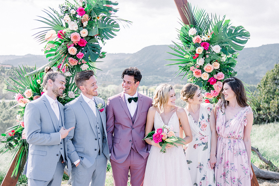 emerald-peak-temecula-wedding-bridal-party-bridesmaids-in-floral-gowns-groomsmen-in-light-blue-suits-bride-in-a-blush-toned-ballgown-with-straps-and-groom-in-rose-pink-suit