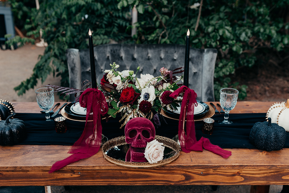  wooden table with black linens and tall black candles