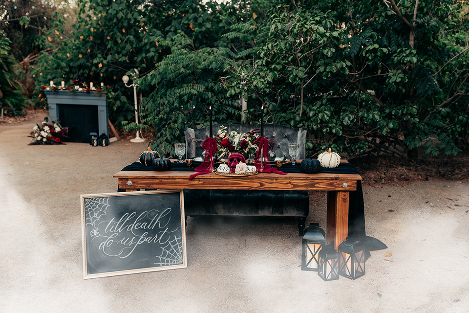  wooden table with black linens and tall black candles
