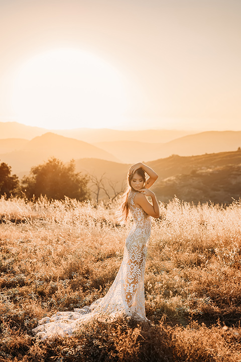  bride in a white bohemian style lace gown with a straps and a her hair in loose waves 