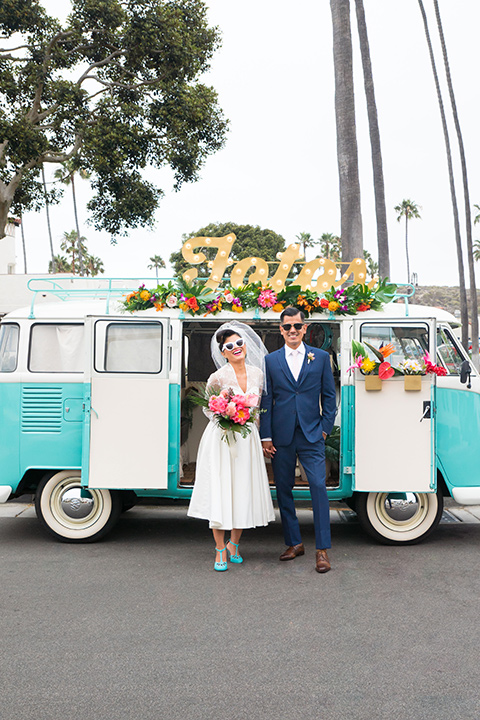 Ole-Hanson-Beach-Club-bride-and-groom-by-bus-the-bride-wore-a-tea-length-retro-inspired-gown-with-lace-sleeves-and-an-elbow-length-veil-the-groom-wore-a-dark-blue-suit-with-a-light-pink-long-tie-and-brown-shoes