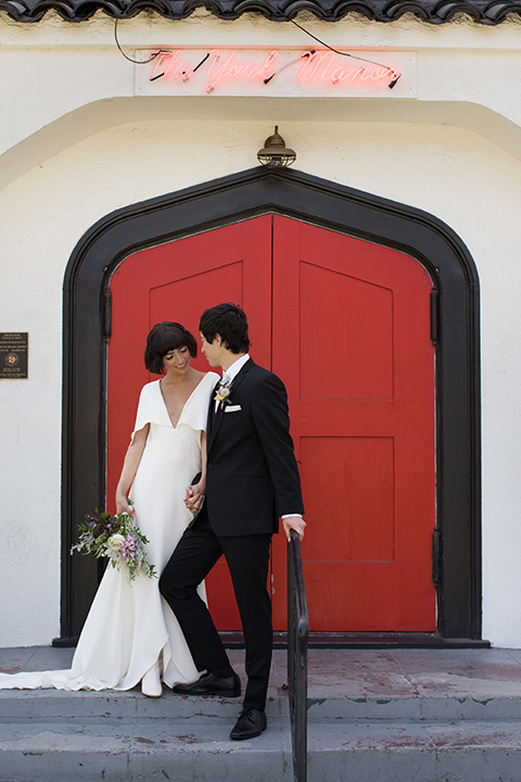 Modern-Mystical-Styled-shoot-at-the-york-bride-and-groom-outside-venue-by-red-door-bride-in-a-bohemian-gown-with-beading-and-groom-in-a-black-suit-with-a-tie