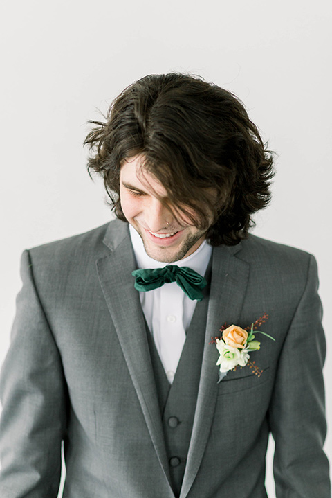 Spring-styled-shoot-groom-close-up-in-a-grey-suit-with-a-green-velvet-bowtie