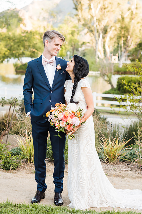 Supriya-and-Chris-wedding-bride-and-groom-looking-at-each-other-the-bride-in-a-white-formfitting-gown-and-the-groom-in-a-navy-suit-with-pink-bow-tie