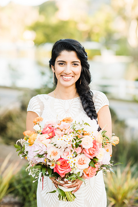 Supriya-and-Chris-wedding-bride-holding-flowers-in-a-white-lace-formfitting-gown