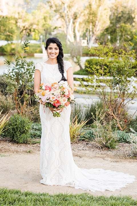 Supriya-and-Chris-wedding-bride-standing-in-a-white-lace-formfitting-gown