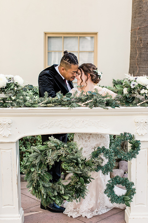 Maxwell-House-bride-and-groom-in-ceremony-space-bride-wearing-a-lace-long-sleeved-gown-groom-wearing-a-black-velvet-jacket