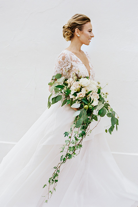 flower-market-shoot-bride-alone-walking-bride-in-a-flowing-tulle-ball-gown-with-lace-sleeves-and-hair-up