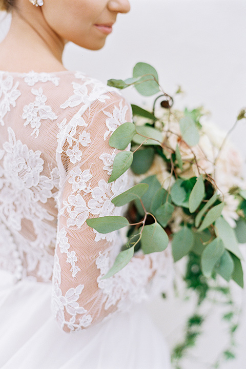 flower-market-shoot-bride-holding-flowers-bride-in-a-flowing-tulle-ball-gown-with-lace-sleeves-and-hair-up