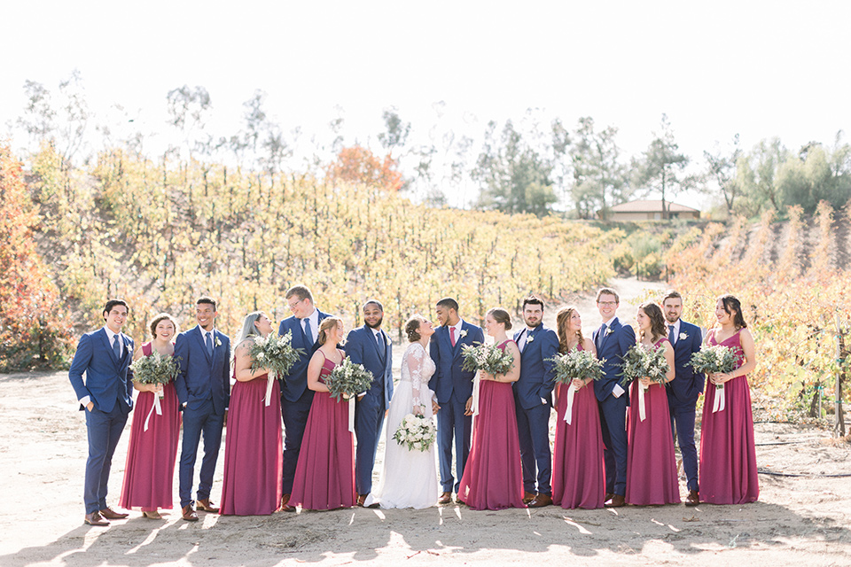 community-church-wedding-bridal-party-bridesmaids-in-a-pink-berry-color-groomsmen-in-cobalt-suits-with-blue-ties-bride-in-a-flowing-gown-with-long-sleeves-and-an-illusion-bodice-groom-in-a-cobalt-blue-suit-with-a-berry-colored-tie