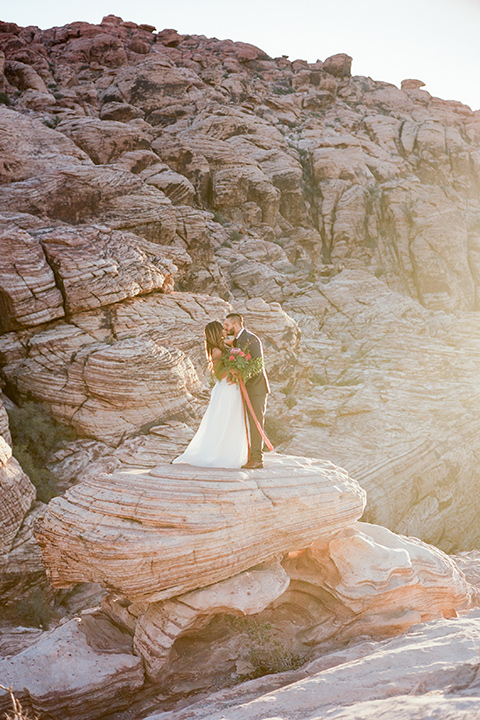 red-rocks-shoot-couple-on-rock-bride-in-a-flowing-white-gown-groom-in-a-grey-suit