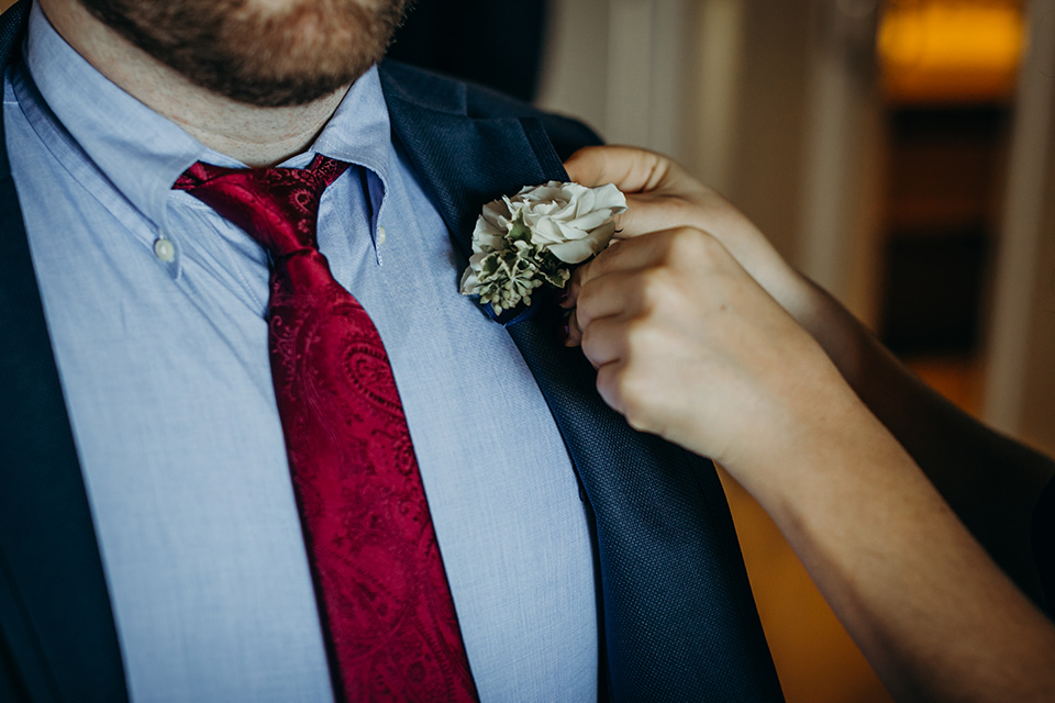 la-jolla-wedding-close-up-on-groom-attire-groom-in-a-dark-blue-suit-with-a-light-blue-suit-and-red-tie