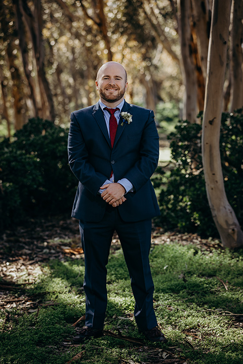 la-jolla-wedding-groom-in-a-dark-blue-suit-with-a-light-blue-shirt-and-red-tie