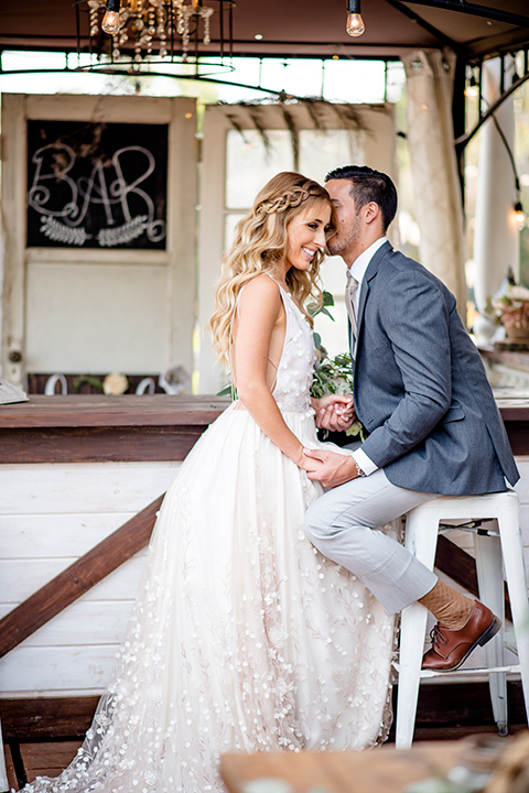 Blossom-valley-victorian-wedding-shoot-bride-and-groom-at-the-bar-bride-wearing-a-tulle-ballgown-with-a-deep-v-and-groom-wearing-a-mix-and-match-look-with-light-grey-pants-and-a-dark-grey-coat