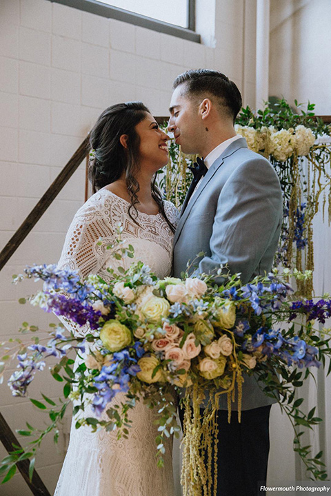 gather-venues-bride-and-groom-at-ceremony-bride-wearing-a-bohemian-lace-gown-with-sleeves-while-the-groom-wore-a-light-blue-suit-coat-with-dark-blue-suit-pants