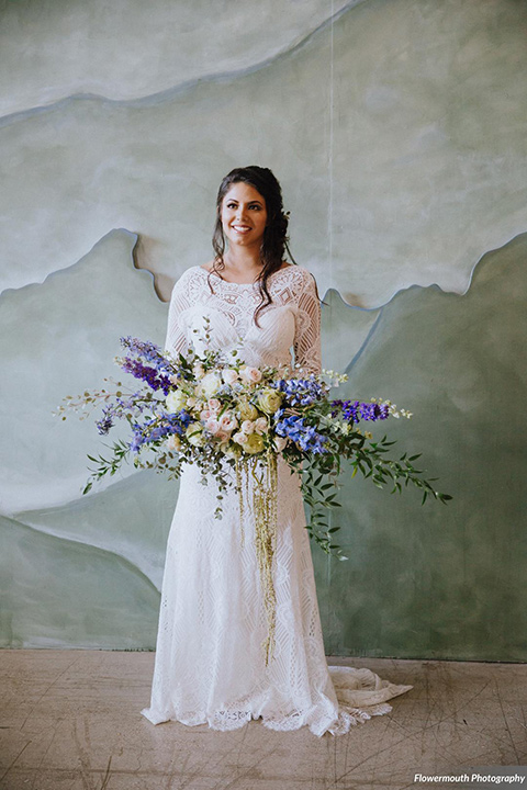 gather-venues-bride-alone-bride-iswearing-a-fitted-lace-dress-with-long-sleeves-and-a-high-neckline-with-a-big-floral-bouquet