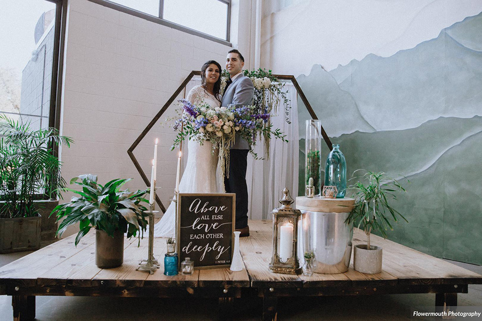 gather-venues-ceremony-space-where-the-bride-is-wearing-a-lace-gown-with-sleeves-and-a-high-neckline-groom-is-wearing-a-light-blue-coat-and-dark-blue-pants-combination