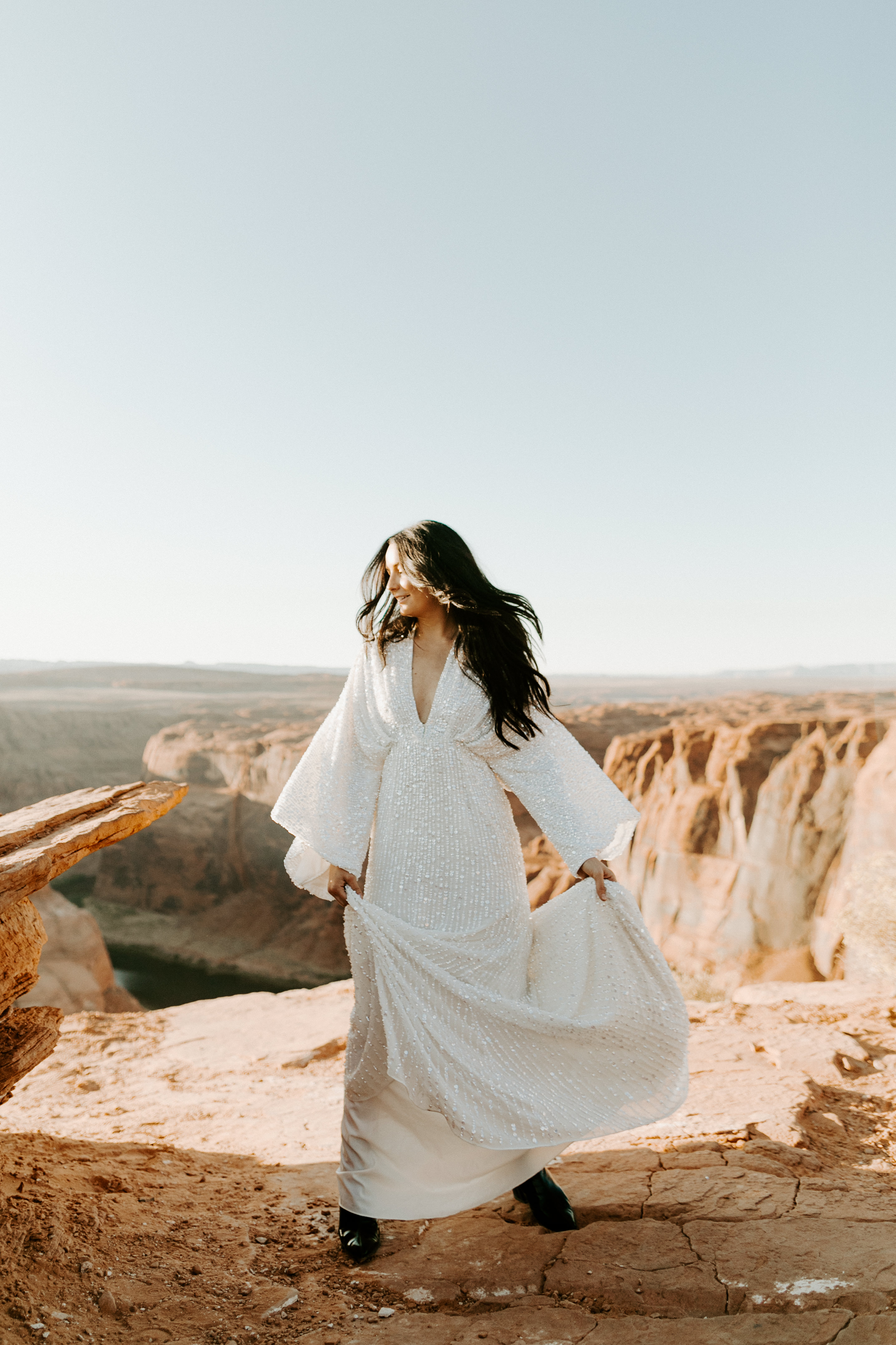  bride in an ivory long gown with bellowing sleeves and a boho design dancing