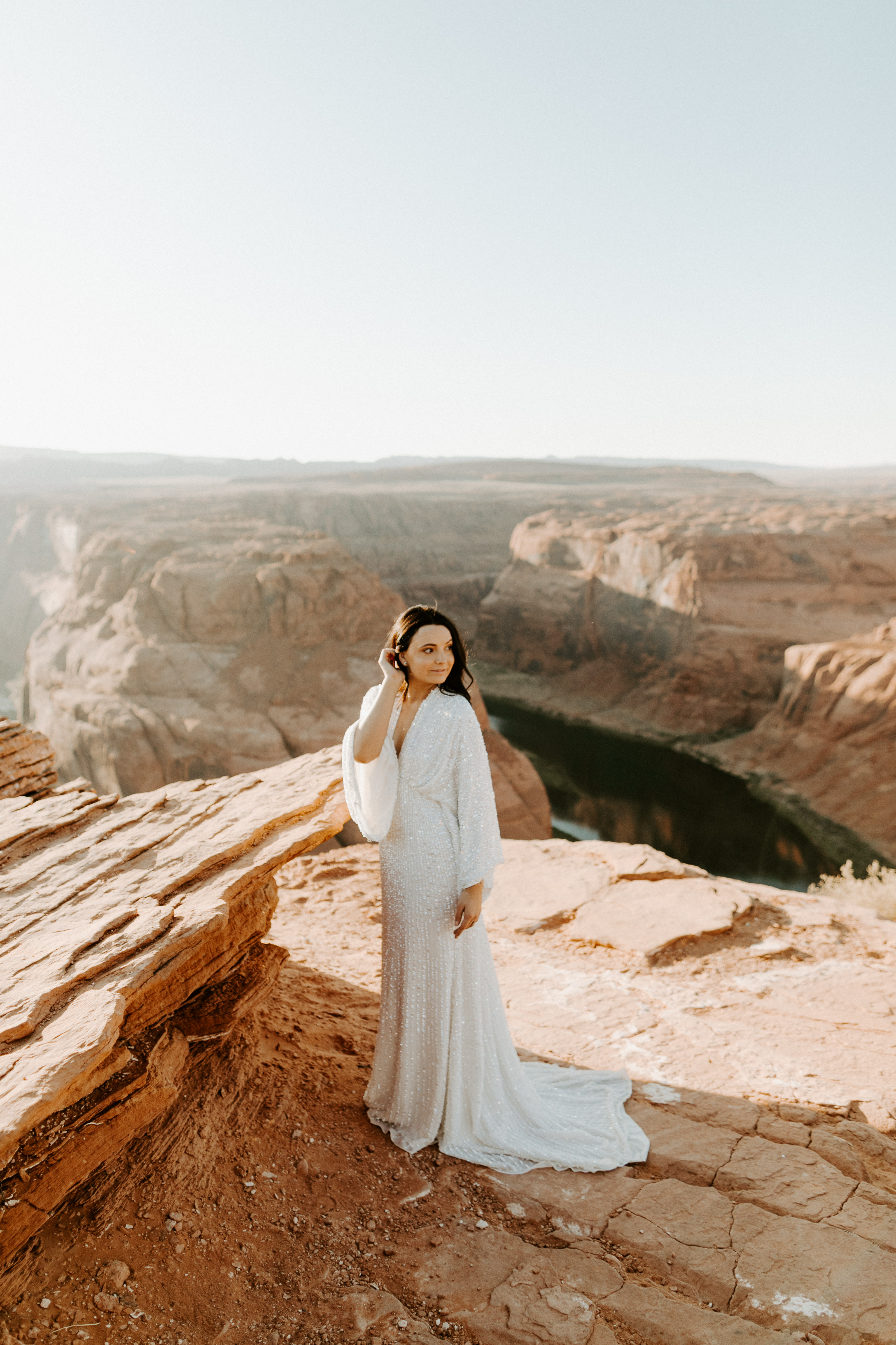  bride in an ivory long gown with bellowing sleeves and a boho design standing