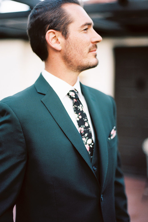  groom in a green suit with a floral tie