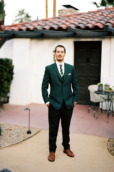  groom in a green suit with a floral tie 
