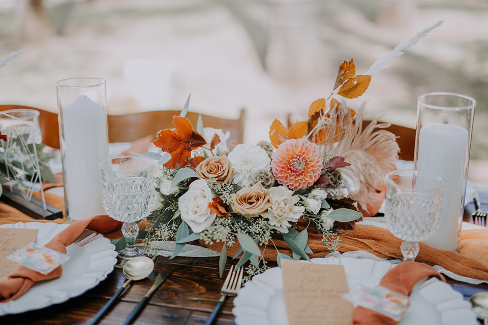  farmhouse table with white and burnt orange linens and gold flatware