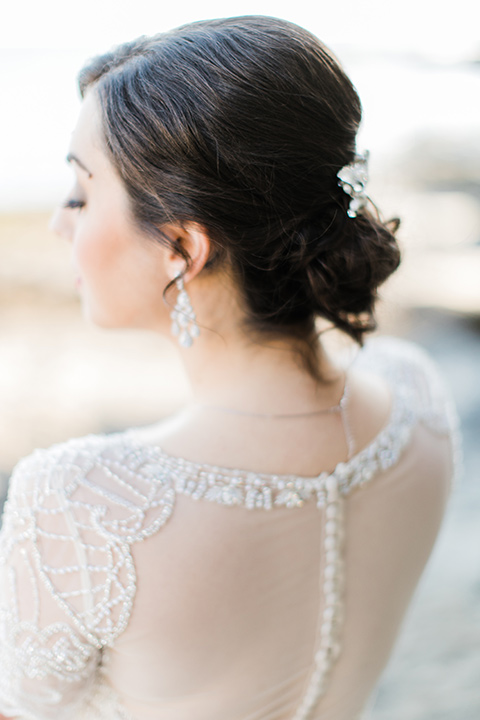  bride in a flowing gown with an illusion neckline and hair in a soft updo with a crystal pin detail 