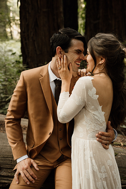  formfitting bridal lace gown with sleeves and the groom in a caramel suit with long tie 