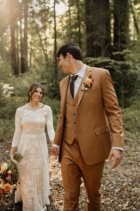  formfitting bridal lace gown with sleeves and the groom in a caramel suit with long tie