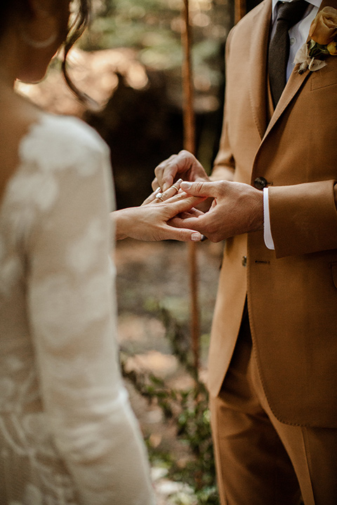  formfitting bridal lace gown with sleeves and the groom in a caramel suit with long tie