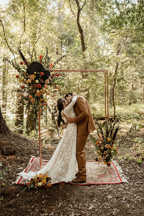  formfitting bridal lace gown with sleeves and the groom in a caramel suit with long tie 