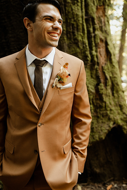  formfitting bridal lace gown with sleeves and the groom in a caramel suit with long tie 