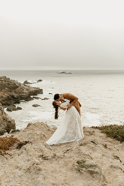  formfitting bridal lace gown with sleeves and the groom in a caramel suit with long tie